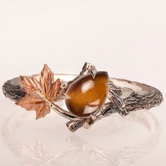 "A handmade 14k twig and leaf ring made in two gold colors and set with a high-quality tiger's eye. The tiger's eye is a 100% natural gem that is cut into a pear shape and measures 5mx7mm. The grooves in the band are plated with black rhodium which emphasizes the texture. if you prefer not to apply the black rhodium that is fine. I can also use white, rose, or yellow gold for the band and the leaves for the same price. If you are looking at this ring then you are probably looking for something s Tiger Eye Engagement Ring, Tigers Eye Wedding Ring, Animal Engagement Ring, Leaf Ring Engagement, Nature-inspired Rings With Polished Finish, Animal Rings Jewelry, Fox Ring, Gold Tiger Eye, Twig Ring