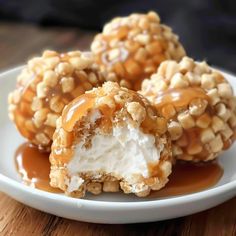 three desserts on a white plate covered in caramel and marshmallow topping