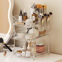 an organized makeup organizer on a desk with brushes, cosmetics and other personal care items