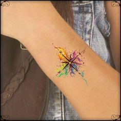 a woman's arm with a colorful tattoo design on the left side of her arm