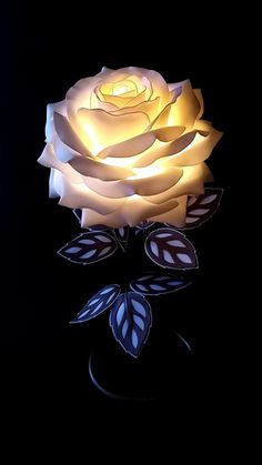 a lit up rose sitting on top of a table