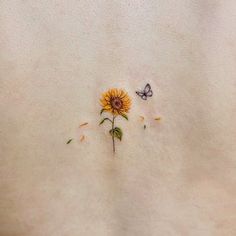 a sunflower and a butterfly are embroidered onto the back of a woman's stomach