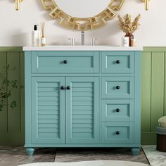 a bathroom with green walls and a gold mirror on the wall over the sink is a blue cabinet that has shuttered doors