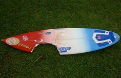 a surfboard that is laying on the ground in the grass with it's bottom part missing