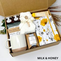 an open box containing coffee, tea, and other items with the words milk & honey written on it