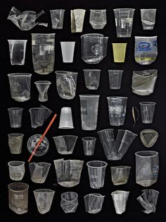 an assortment of glassware is displayed on a black background, including cups and spoons