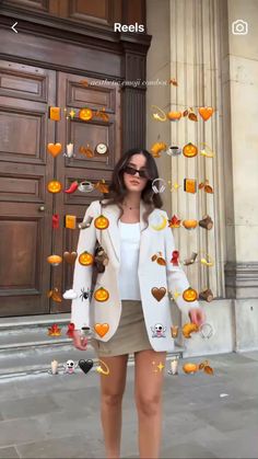 a woman standing in front of a building with lots of oranges on the door