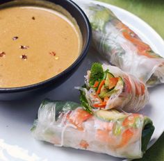 two rolls on a plate next to a bowl of soup and some sort of dipping sauce