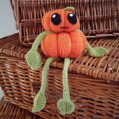 a knitted pumpkin sitting on top of a wicker basket