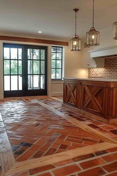 an empty kitchen with brick flooring and wooden cabinets in the center, surrounded by glass doors