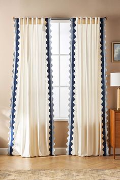 a living room with white curtains and blue trim