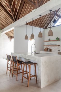 a kitchen with two stools next to an island