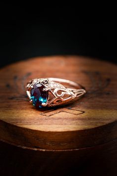 a close up of a ring on top of a wooden table with a black background