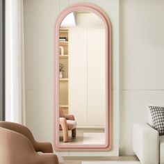 a living room with a couch, chair and large pink mirror in the middle of it