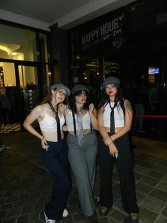 three women wearing hats and ties posing for the camera in front of a happy hour sign