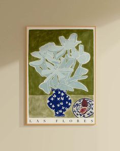 a blue and white vase with flowers in it hanging on the wall next to a lamp