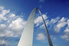 a tall monument with a sky background and clouds in the foreground, as seen from below