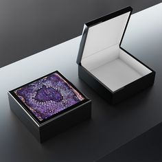 an open box with a purple and black design on the inside is sitting on a table