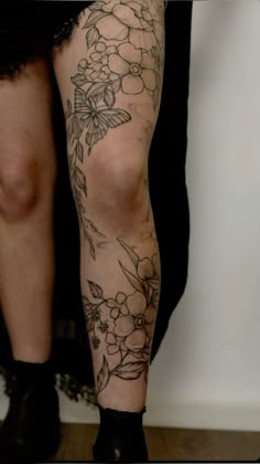 a woman's legs with flowers and butterflies on them