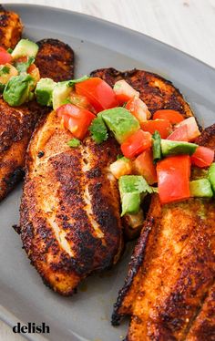 grilled chicken with tomatoes, avocado and lettuce on a plate