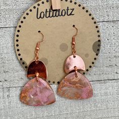 the copper and pink earrings are on display