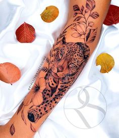 a woman's arm with a tattoo on it that has a cheetah and flowers