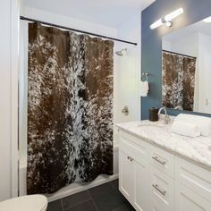 a bathroom with two shower curtains and a toilet in the corner, next to a sink