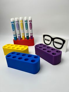 four legos with glasses and markers on them