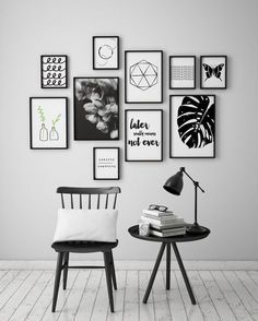 a chair and table in front of a white wall with many pictures on the wall