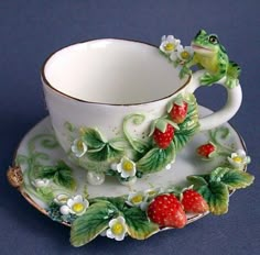 a tea cup and saucer with a frog on it