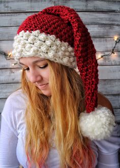 a woman wearing a red and white knitted santa hat