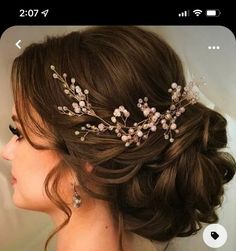 a woman wearing a bridal hair comb with flowers on it's head and pearls in her hair