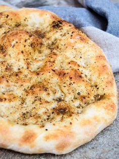 a pizza sitting on top of a table next to a blue towel