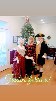 three people dressed in period costumes standing next to a christmas tree with the caption felin festive