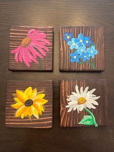 four wooden blocks with painted flowers on them