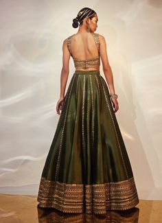 Presenting the Green and Gold Embellished Silk Lehenga Set, crafted from luxurious dola silk, is a true masterpiece that blends traditional elegance with a contemporary twist. The deep green lehenga is adorned with intricate hand embellishments, infusing the ensemble with a regal charm that’s hard to miss. Teamed with the blouse is thoughtfully designed to harmonize with the rich tones of the skirt, while the matching dupatta drapes effortlessly, adding to the outfit's overall opulence. Ideal for Mehndi, Sangeet, or as a stunning choice for wedding guest attire, this lehenga set promises to make you the center of attention at any event. Composition : Blouse, Lehenga and Dupatta - Dola Silk Care: Dry Clean Only and Vacuum Storage This product can be customized for sleeves, blouse length and Saree For Wedding Guest Indian Outfits, Green Lehenga Choli Wedding, Silk Lehnga Outfit, Green Blouse Lehenga, Wedding Guest Indian Outfit, Green Choli Lehenga, Green Art Silk Lehenga With Traditional Drape, Green Saree Blouse Designs, Transitional Season Green Silk Lehenga