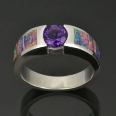 Stunning lab created opal ring with a purple amethyst center stone set in sterling silver. This unique ring is inlaid with 3 pieces of multicolor lab created opal on each side of the ring. The lab created opal in this ring fires red, orange and yellow with a purple base color and hints of blue and green. The .75 carat round amethyst is set almost flush with the silver and the deep purple color looks great with the lab created opal. I took special care to cut the lab created opal to mimic the ran Fusion Style Opal Gemstone Jewelry, Opal Multi-stone Ring, Opal Multi-stone Ring Jewelry, Fusion Style Round Opal Ring, Purple Opal Round Jewelry, Modern Round Opal Jewelry, Modern Formal Opal Jewelry, Purple Opal Gemstone Jewelry, Opal Inlay Ring Gift