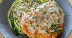 a close up of a plate of food with meat and vegetables on it, including zucchini