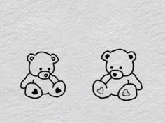 two teddy bears sitting next to each other on a white paper background with black ink