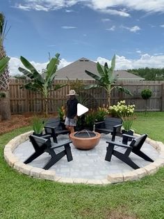 a man standing in the middle of a yard with chairs and a potted plant