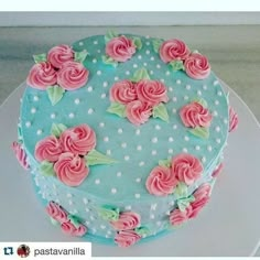 a blue cake with pink flowers on it