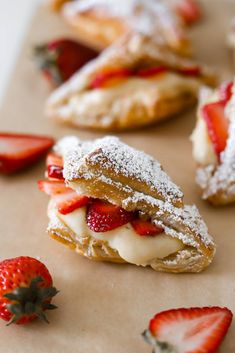 strawberry shortcakes with powdered sugar and fresh strawberries on the side, ready to be eaten