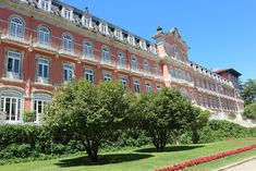 a large red building with many windows and balconies on the top floor is shown