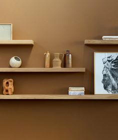 three wooden shelves with vases and pictures on them