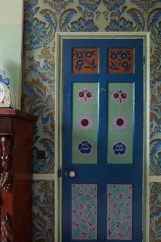 a blue and green door sitting next to a wooden dresser