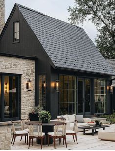 a patio with chairs, tables and an outside dining area in front of a house