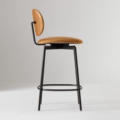 an upholstered bar stool with a wooden seat and back rests against a white background