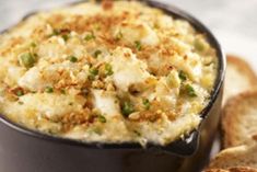 a black bowl filled with mashed potatoes next to slices of bread