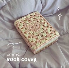 a crocheted book cover laying on top of a bed