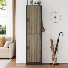 a tall cabinet in the corner of a living room with an umbrella and other items